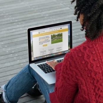 Woman using laptop to view Xavier website