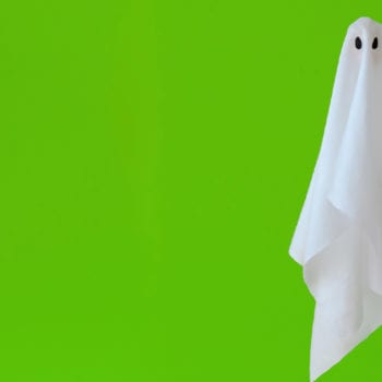 Sheet ghost floating in front of green background