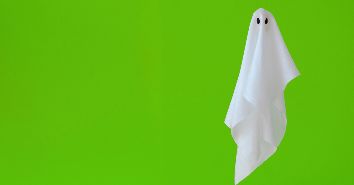Sheet ghost floating in front of green background