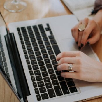 Hands typing on a computer