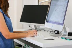 An Online Optimism employee using our office's standing desk.