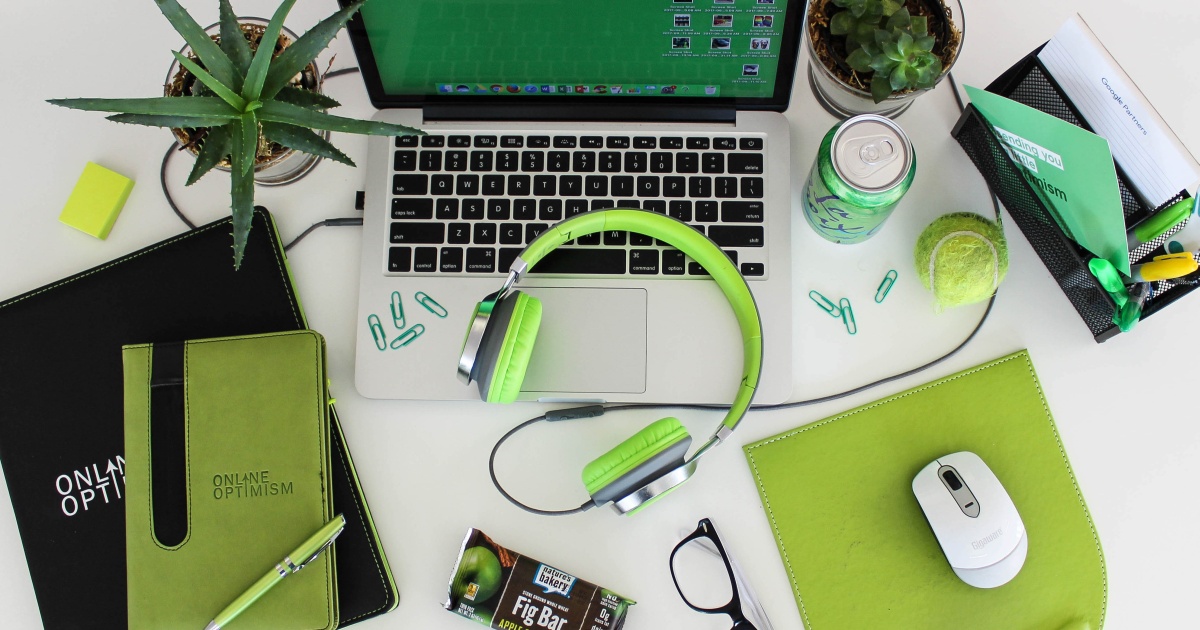 Desk containing lots of green items and a laptop