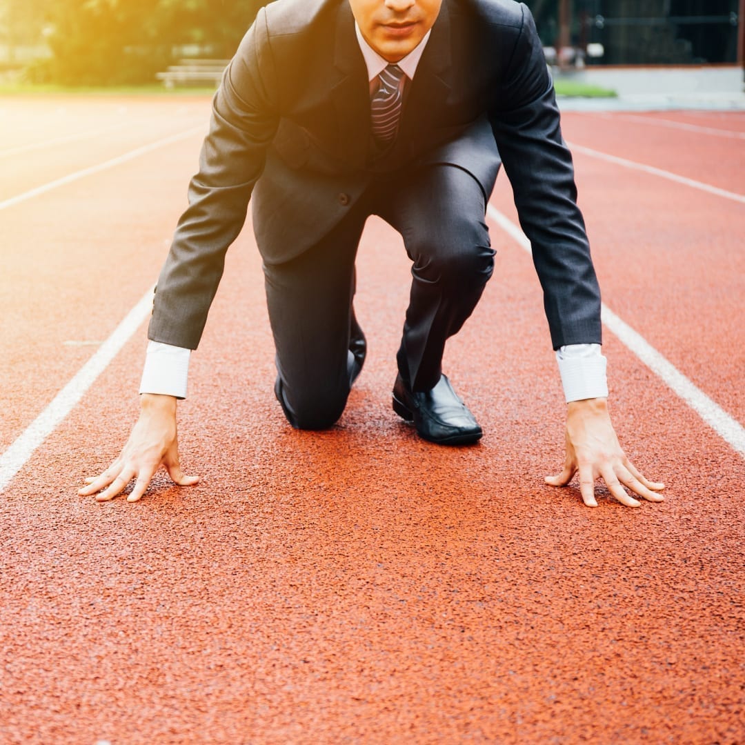 Business man crouching on a track