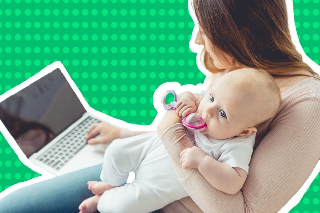 A woman sits at her computer to work from home with a baby.