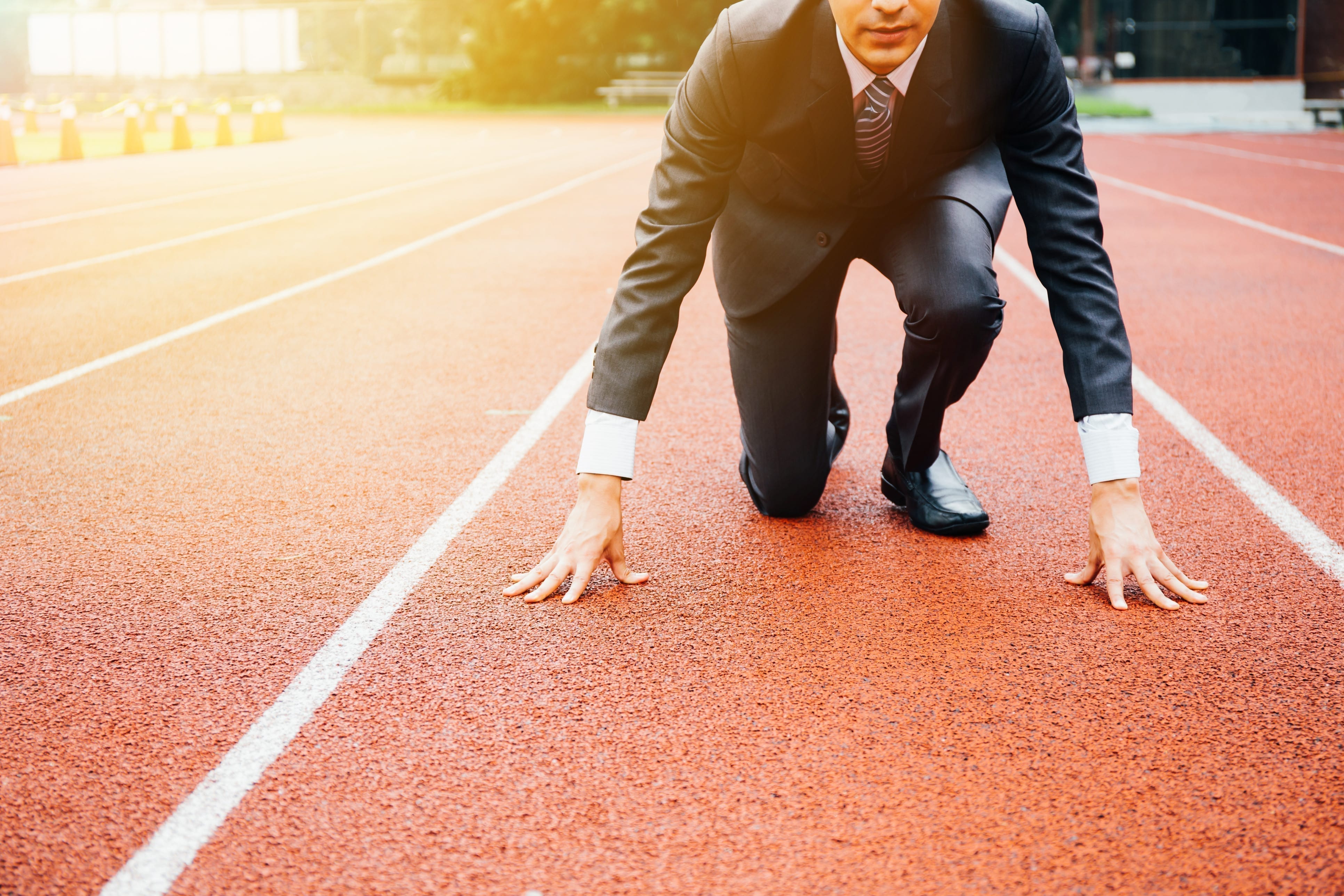 Business man crouching on a track