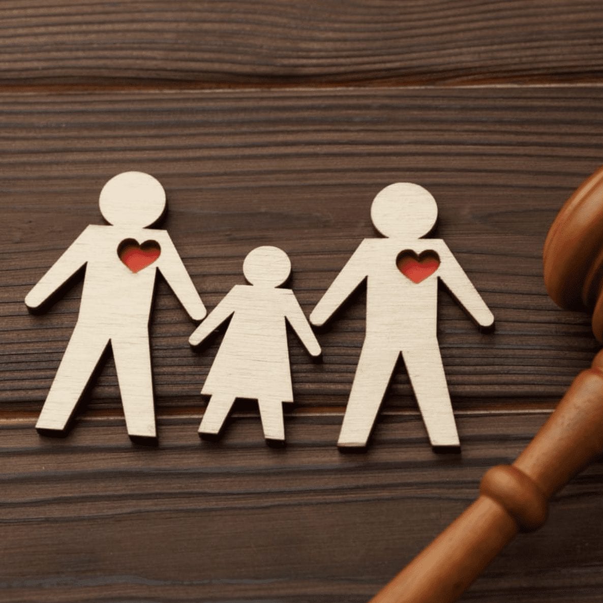 Wood cutout of two parents and a child next to a gavel