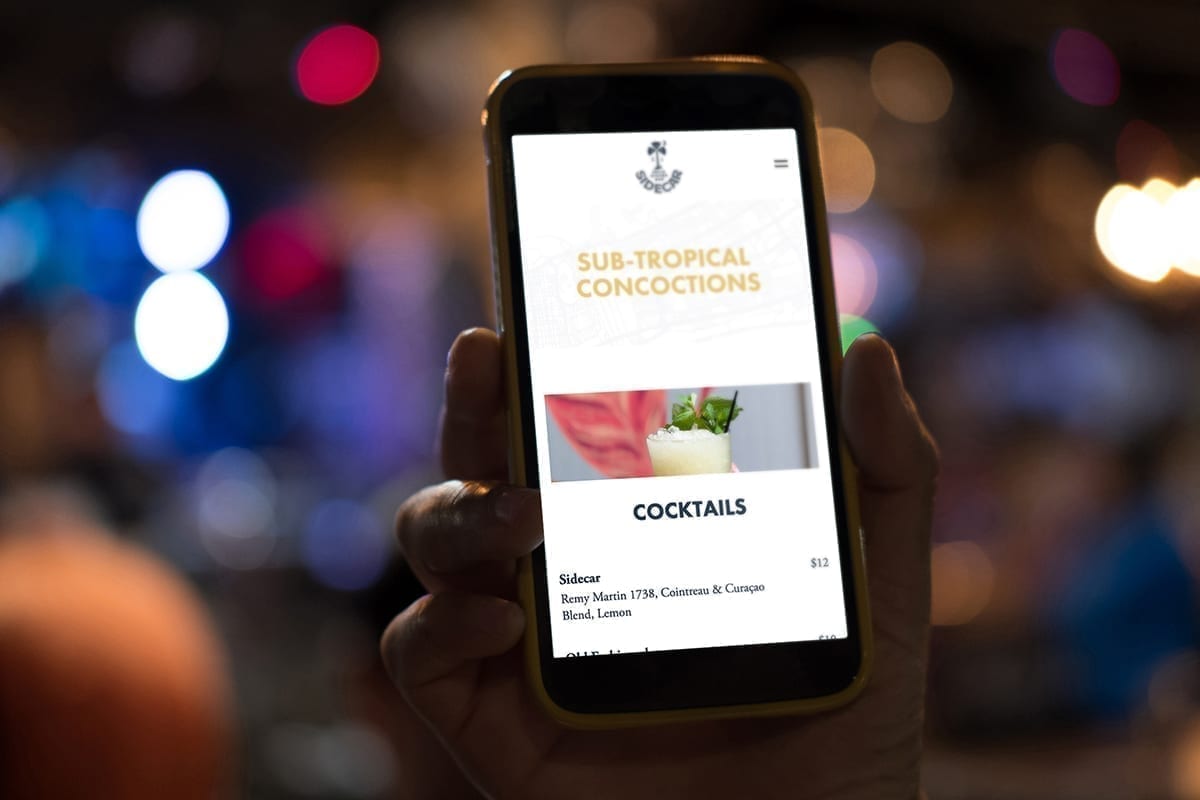 Person uses Sidecar's new website on a phone at a bar