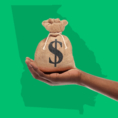 Hand holding moneybag over state of Georgia outline
