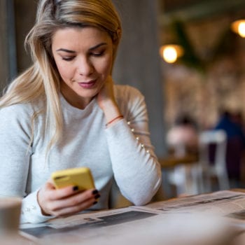 Woman holding and looking at phone