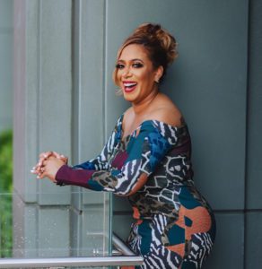 business woman leaning over a balcony smiling at the camera