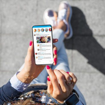 Woman using social media microblogging app on her phone