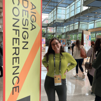 Claire stands next to an AIGA Design Conference sign at the Seattle Convention Center