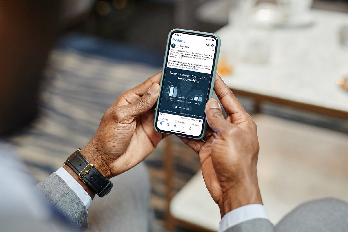 Businessman looks at a data visualization post from The Data Center on his phone