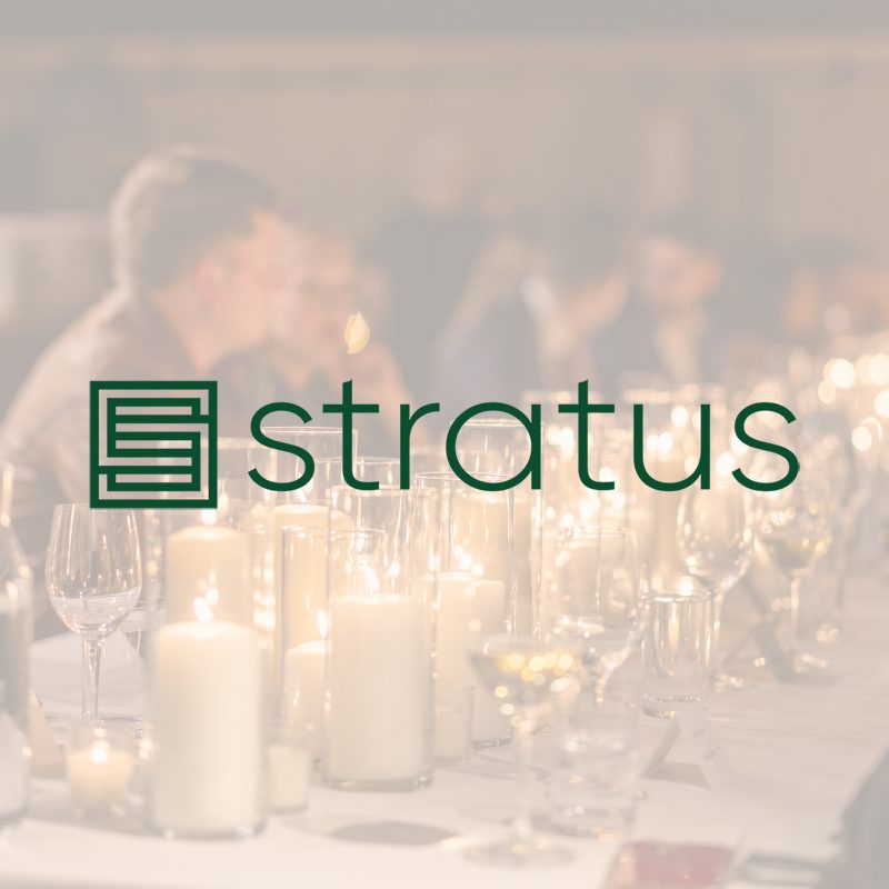 The logo for Stratus Firm, overlaid on a photo of a formal dinner event.