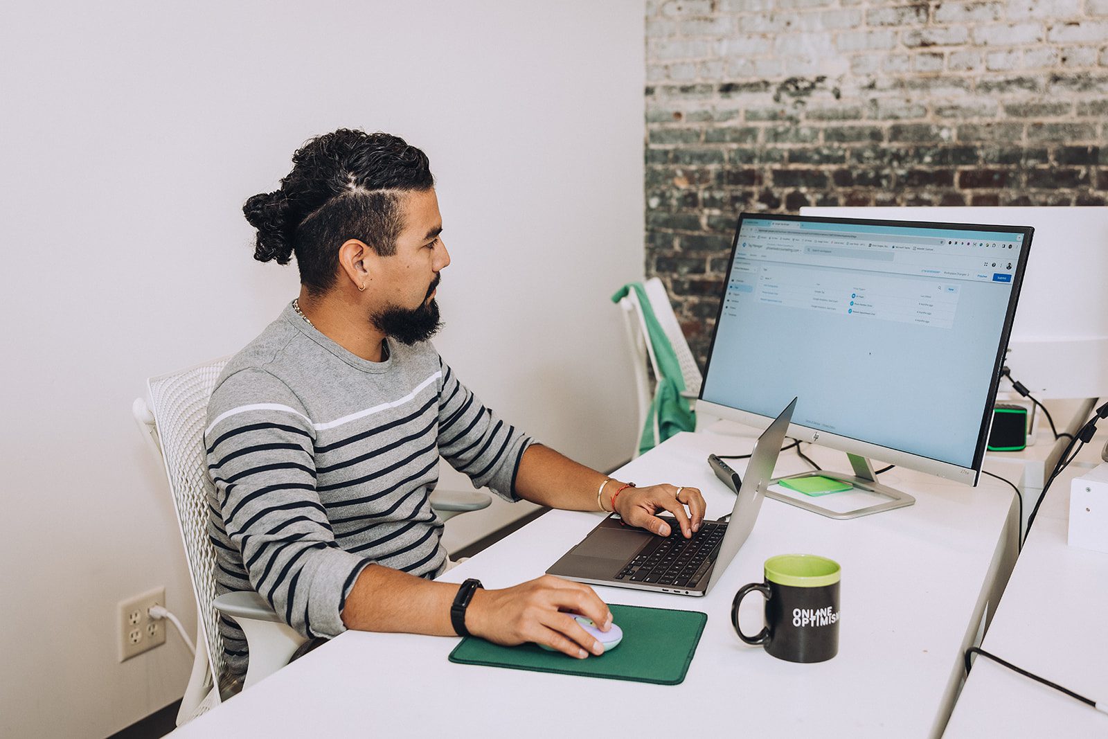 Esteban looks at a Google Analytics page in the Online Optimism office.