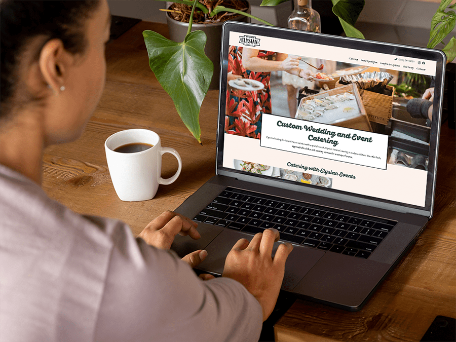 Woman uses Elysian Events Catering's new website on a laptop in her living room